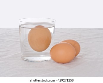 Rotten Egg, Salmonella Risk. Old Fashioned Test. Bad Egg Floats In Glass Of Water.