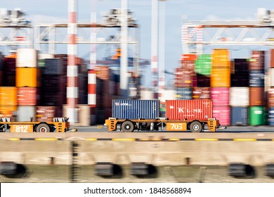 Rotterdam, Netherlands - 11-05-2020: Panning Shot Of Automated Guided Vehicle Carrying Two Containers On The Quay Of A Rotterdam Port Terminal