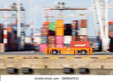 Rotterdam, Netherlands - 11-05-2020: Panning Shot Of Automated Guided Vehicle Carrying A Container On The Quay Of A Rotterdam Port Terminal