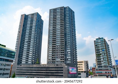 Rotterdam Netherlands - August 22 2021; Brutalist concrete and glass stark high-rise apartment blocks tower above the city's urban landscape.