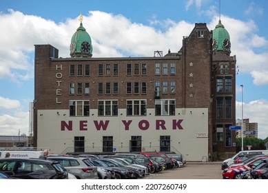 Rotterdam, Netherlands - July 11, 2022: Back Side Of Brown Stone Historic New York Hotel With 2 Green Dome Towers Under Blue Sky On Kop Van Zuid Dock And Quay. Cars Om Parking Add Colors