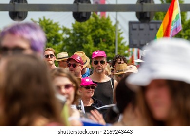 ROTTERDAM, THE NETHERLANDS – June 18th,2022: Gay Pride-Pink Saturday Street Parade-Festival. Man With Pink Cap In A Group Of People Showing Their Pride During The Annual Gay Pride In Rotterdam