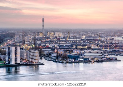 Rotterdam, The Netherlands, November 12, 2018: residential buildings and harbour installations around Waalhaven harbour under a pink sky at sunset - Shutterstock ID 1255222219