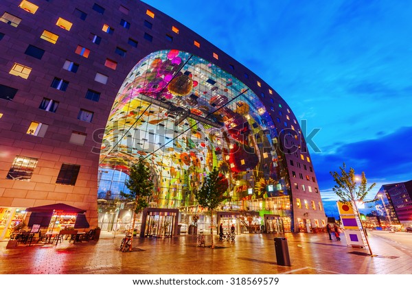 ROTTERDAM,\
NETHERLANDS - SEPTEMBER 03, 2015: modern market hall in Rotterdam\
at night. It was opened Oct 1, 2014 by Queen Maxima, designed by\
architect firm MVRDV. With unidentified\
people