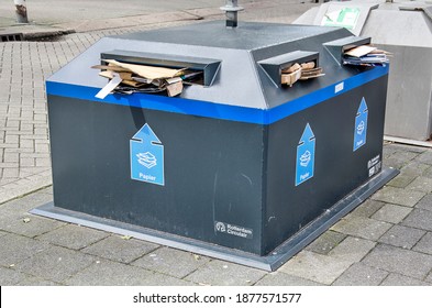 Rotterdam, The Netherlands, September 12, 2019: Large Pieces Of Cardboard Sticking Out Of A Blue Steel Paper Recycling Container On The Pavement