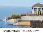 Rotunda and lighthouse on the embankment of the city of Blagoveshchensk, Russia in autumn 2021. Increased water level in the Amur River after the summer flood. Yellow foliage of trees in a city park.