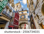 ROUEN, NORMANDY, FRANCE - 2024: "Gros-horloge", Great Clock, passageway under a renaissance astonomical clock, in a cobbled pedestrian shopping street, with half-timbered houses and stone mansions