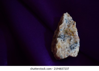 Rough beryl on dark purple background, a closeup of yellow white blue mineral on day light, a macro shot.A closeup of natural rock isolated on purple background.Geology, mineralogy. - Shutterstock ID 2194837237