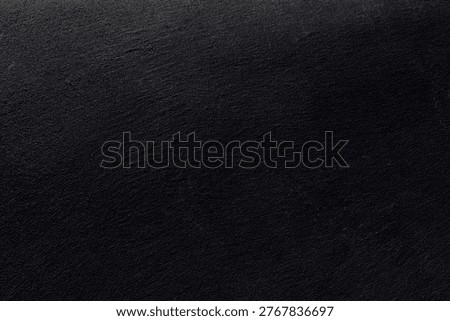 Close‑up of rough black surface showing subtle irregularities, matte finish and fine material texture.Dark textured surface conveying minimalism, depth, elegance and subtle material detail for modern creative backgrounds.