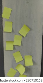 A rough cement wall with a plain yellow paper attached, without any text, creating a minimal and textured urban background. The composition emphasizes raw surface texture, industrial material, simplicity, and color contrast between grey concrete and yellow paper. Ideal for themes such as urban texture, abstract background, construction surfaces, and minimal design