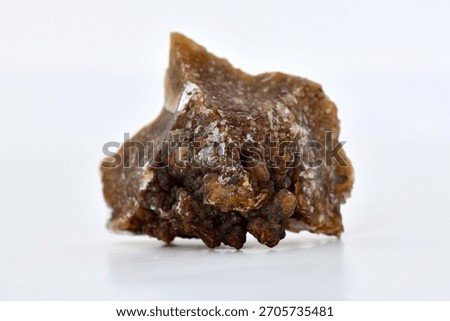 Rough chunk of limonite (hydrous iron oxide) ore. Specimen shows dark brown black core surrounded by rough, yellow-brown and white speckled crust matrix, isolated on white background.