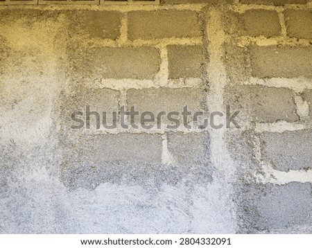 Rough concrete block wall texture with visible mortar lines and unfinished cement surface. The industrial gray brick pattern shows gritty, raw construction details under natural light. This high-resolution background is ideal for architecture, construction, industrial design, urban grunge, texture overlay, building materials, and modern minimalist concepts.