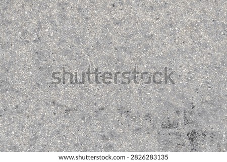 Rough gray concrete texture background with small pebbles, creating an industrial, gritty look