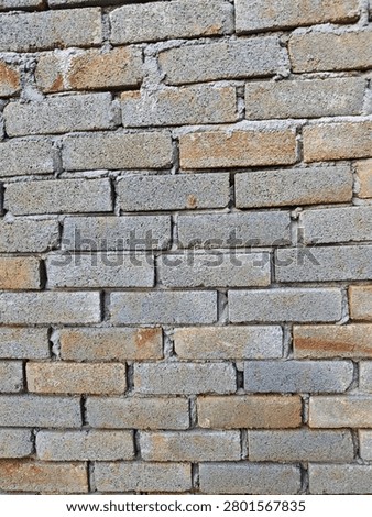 Rough grey brick wall texture with messy cement mortar and weathered surface for architectural background.