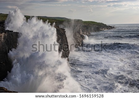 Rough ocean with waves crashing against cliffs in Co. Clare, Ireland