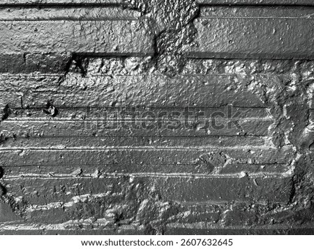 A rough pewter gray surface with distinct horizontal lines and irregular patterns gives an industrial and rugged appearance