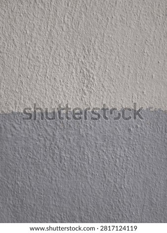 Rough plaster wall texture split horizontally between light grey and darker grey pain