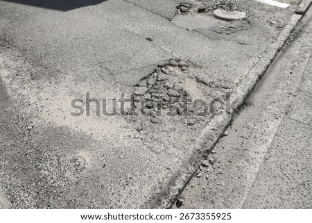 Rough road surface and potholes. Poorly maintained residential road. Translation: Water valve.