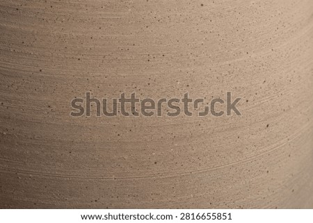 Rough Sandstone Ceramic Pottery Texture. Detailed view of earth toned clay showing horizontal grooves and speckled patterns symbolizing rustic craftsmanship and stability