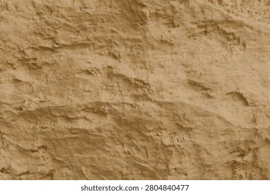 a rough sandstone cliff wall featuring a rich earthy texture. The surface is characterized by irregular crevices, grainy details, and eroded patterns in warm ochre, beige, and tan tones