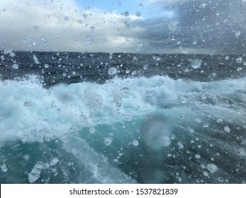 Rough sea swell with white foam, splashes and sea water droplets with dark blue stormy sky and tilted horizon line. - Shutterstock ID 1537821839