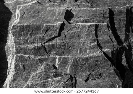 Rough slate rock texture surface with natural cracks and striations.