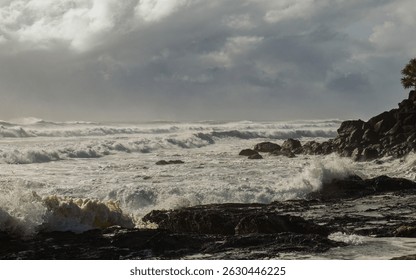 Rough storm surf generated by an approaching cyclone rolls in towards the rocky shore under threatening grey skies at Snapper Rocks at Coolangatta on the Gold Coast in Queensland, Australia.