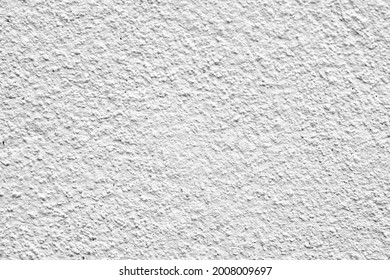 Rough surface of a concrete wall painted in greyish white, concrete wall background, blurred white background.