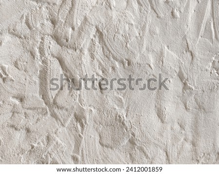 The rough texture of a poorly plastered light-colored wall. An uneven surface with bumps and depressions. Background for the design. Full frame. Copy space. Mock-up.