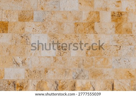 Rough textured limestone wall surface creating a seamless pattern, providing a natural backdrop for construction, architecture, and design