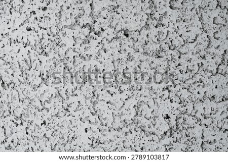 Rough, textured surface with small, irregular indentations.