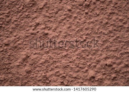 Rough wall texture. Pink bulge texture background on a rough facade wall macro photo. Rough relief of a rough wall surface.