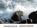 Rough water hitting the rocks ashore during a very windy and sunny day in Toronto, Ontario, Canada.