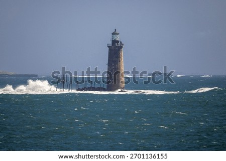 Rough waters bash the rocks around the Ram Island Ledge Light in Portland, Maine.