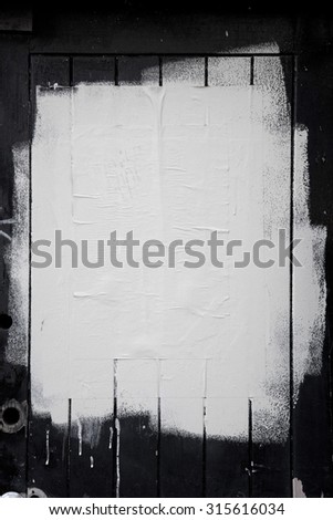 Rough white paint rolled over a black wooden textured background