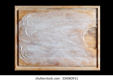 Rough wooden rectangular used cutting board background with flour directly from above on black background