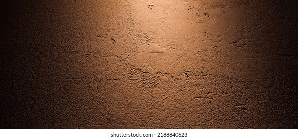 The rough-textured concrete patterned background on maroon wall provide a backdrop of bright light and shadow dark