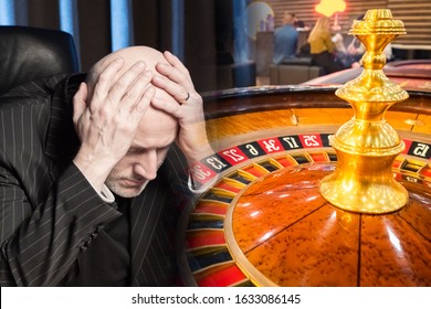 Roulette In A Casino. A Man In Despair In A Casino. Loss. Damages. Bankruptcy. Probability Games For Money. Gambling. The Man Clutched His Head In Front Of The Roulette Table In The Casino. 