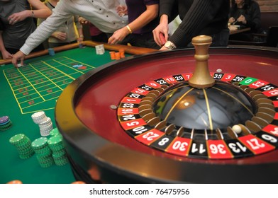 Roulette and piles of chips on a green table