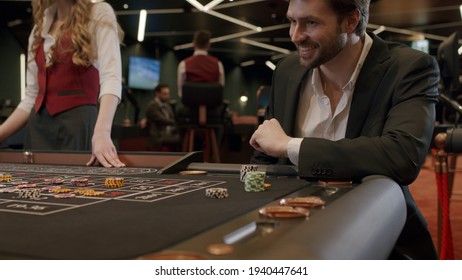 Roulette players place their bets at an elite casino. Gambling, nightlife