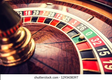 Roulette wheel in casino with ball on green position zero.