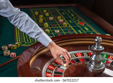 Roulette Wheel And Croupier Hand With White Ball In Casino 