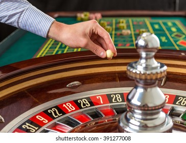 Roulette Wheel And Croupier Hand With White Ball In Casino 