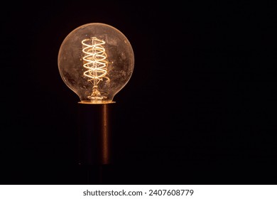 Round Antique Filament Glowing Incandescent Light bulb Tungsten isolated on black background clear glass Edison Bulb - Powered by Shutterstock