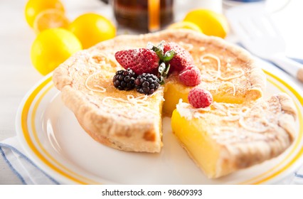 Round Artisan Lemon Tart Decorated with Berries and Powdered Sugar