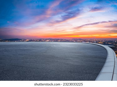 Round asphalt road and city skyline with colorful sky clouds at sunset - Powered by Shutterstock