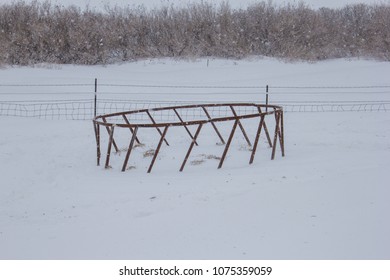 Round Bale Feeder Half Buried In A Snowdrift.