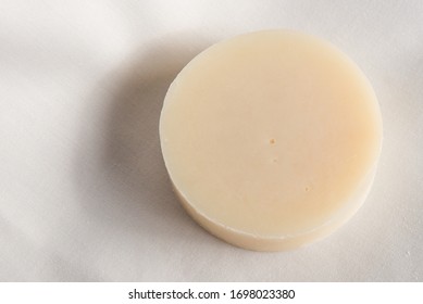 A Round Bar Of Natural Soap On A Plain White Background.