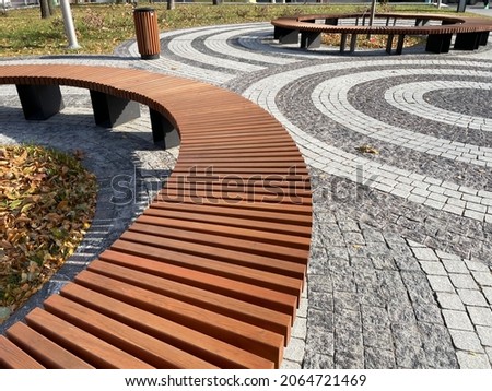 round benches in a tiled square in the city
