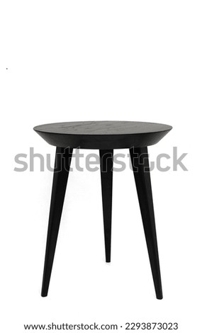 Round black wooden coffee table on three legs with a beautiful wood texture. Isolated on a white background
